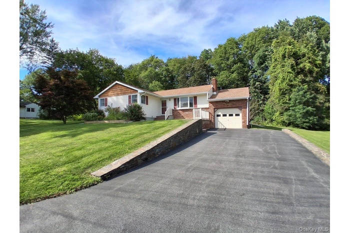 Ranch-style home with a front yard, driveway, and garage