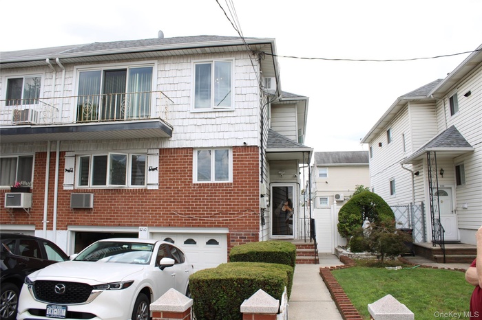 View of front of property with brick siding and roof with shingles
