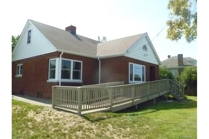 Back of property with a deck and a yard