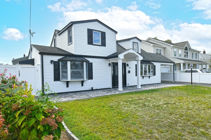 View of front of home with a shingled roof and a patio