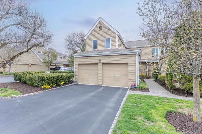 Townhome / multi-family property featuring aphalt driveway and an attached garage