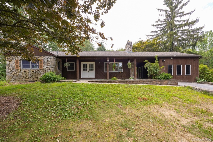Single story home featuring a patio, a chimney, a front yard, and french doors