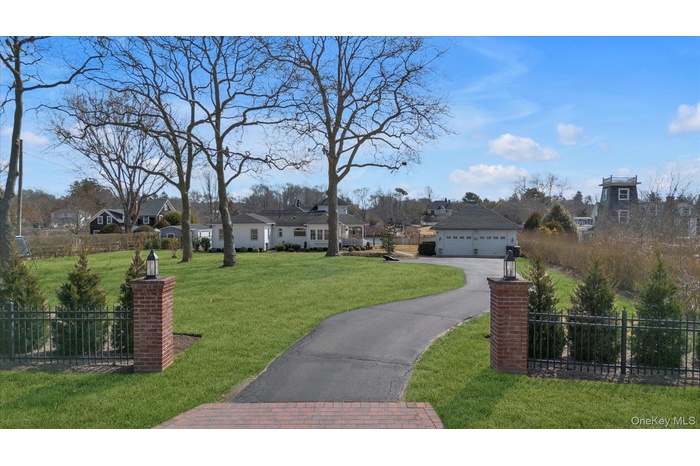 View of front facade with a residential view, a garage, and asphalt driveway