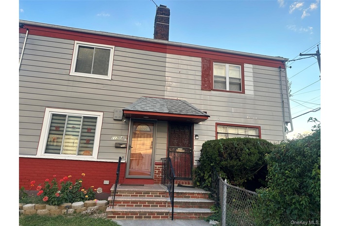 View of front of house with a chimney and brick siding