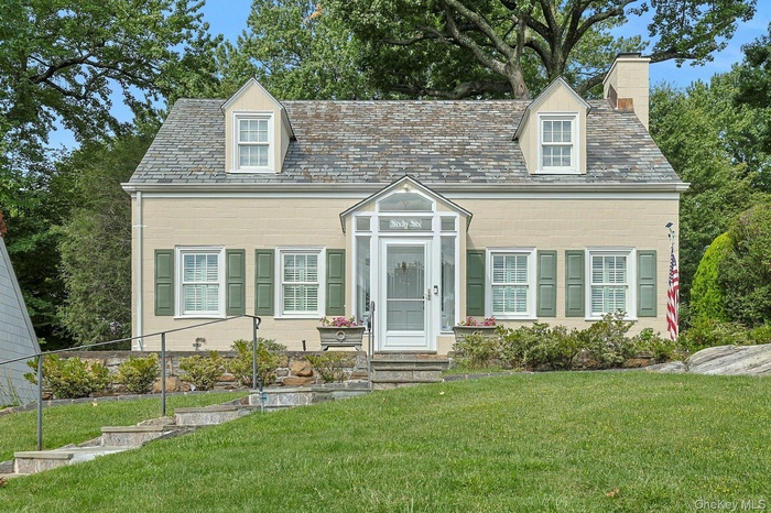 Cape cod home with a high end roof and a chimney