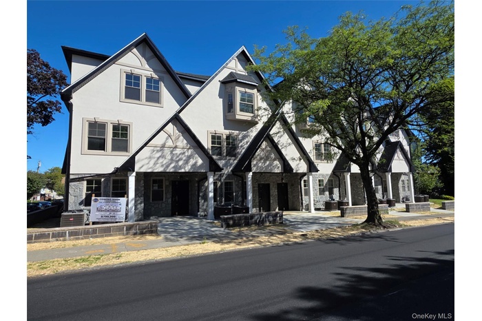 View of front of home featuring stucco siding and stone siding