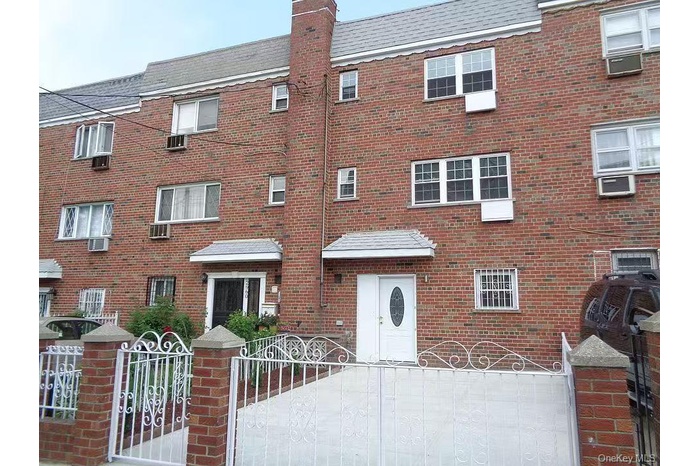 View of front of property featuring a fenced front yard, brick siding, a gate, and a chimney