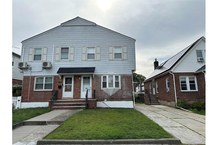 View of front of house with brick siding and a front lawn