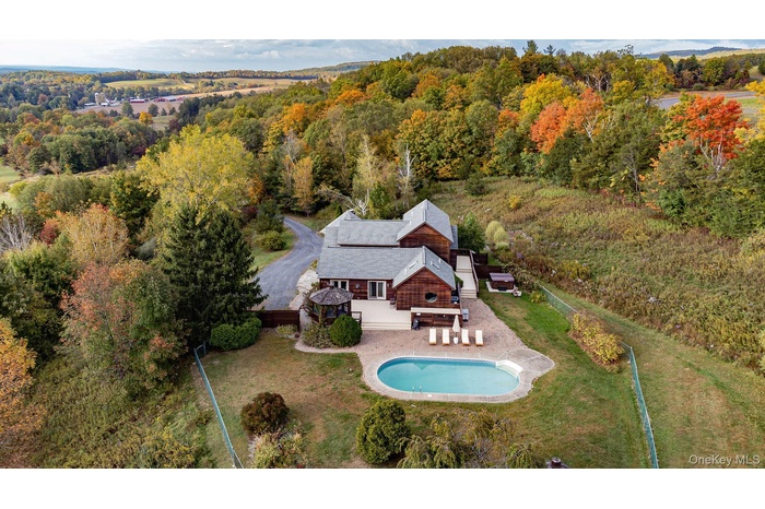 View from above of property with a pool and a forest