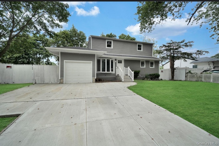 Traditional home featuring a garage and concrete driveway