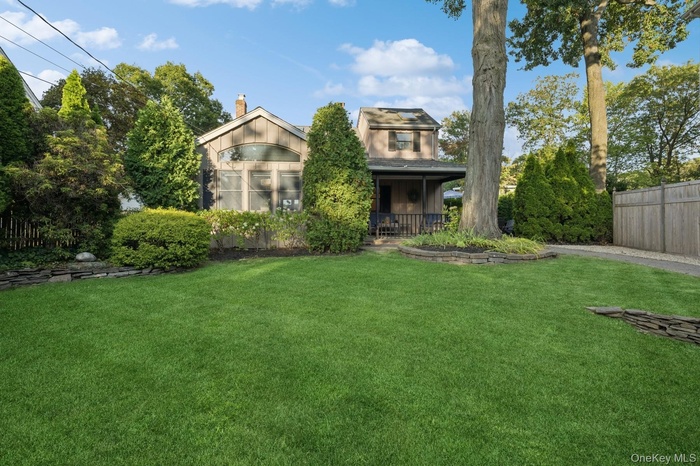 View of front of home with a chimney and a porch