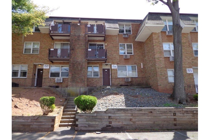 View of front facade with brick siding, stairs, and cooling unit