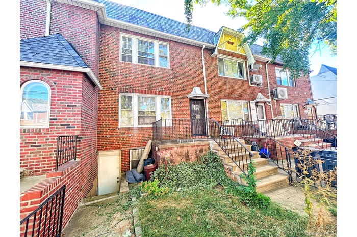 View of front of property featuring brick siding and a high end roof