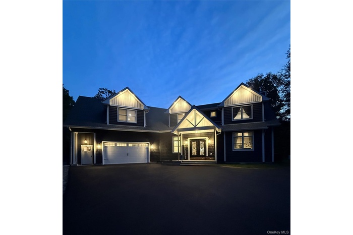 View of front facade with driveway, a garage, and french doors