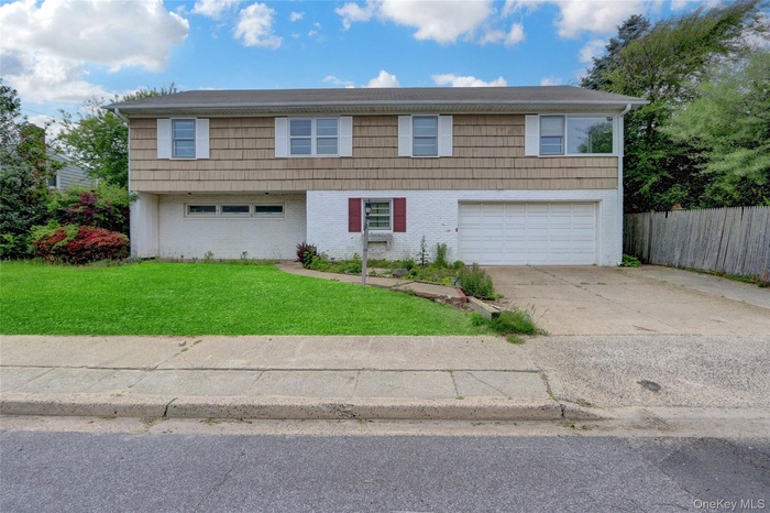 View of front of home with an attached garage, concrete driveway, and brick siding