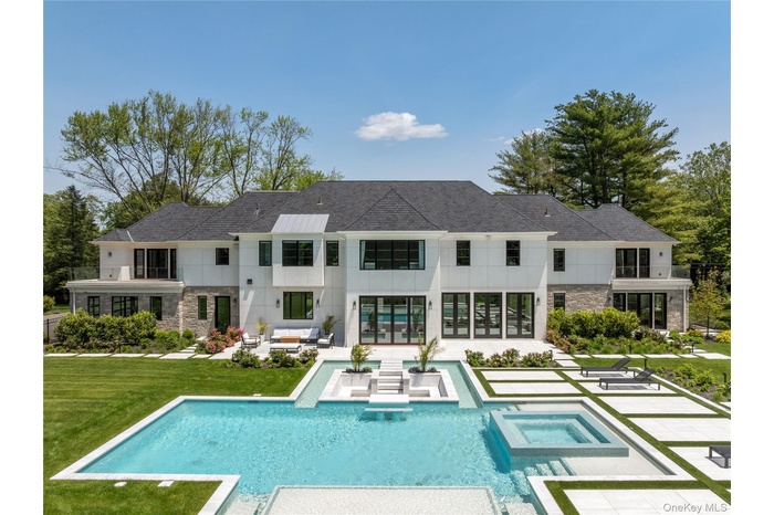 Rear view of house with an outdoor living space, stone siding, a patio area, a lawn, and french doors