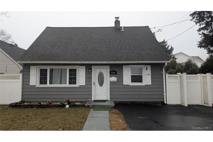 View of front of home with a shingled roof and a chimney