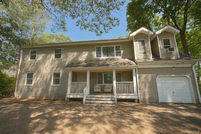 View of front of property featuring a garage and a porch