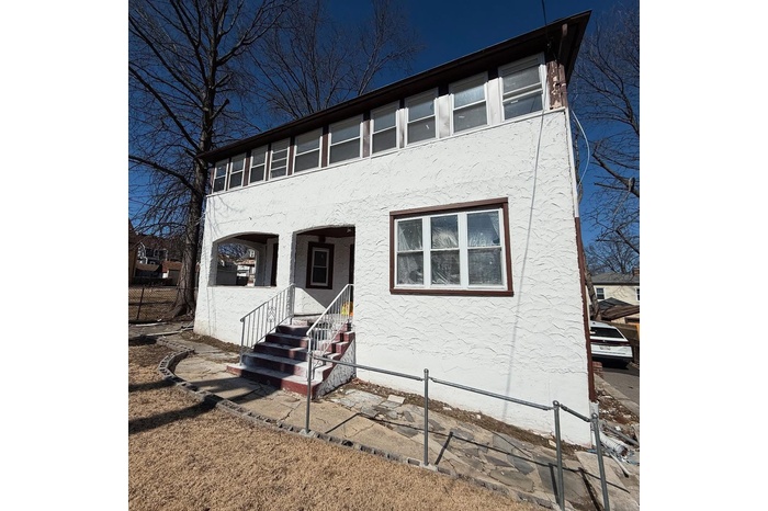View of front of house featuring fence and stucco siding