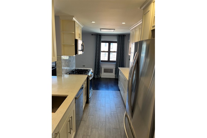 Kitchen featuring stainless steel appliances, dark wood finished floors, tasteful backsplash, recessed lighting, and light stone counters