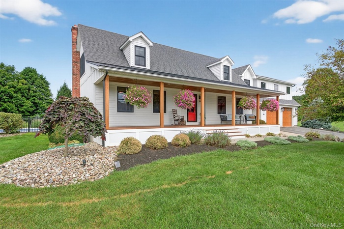 Modern farmhouse with covered porch, a metal roof, and two-car garage