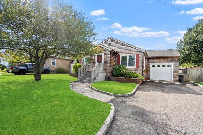 View of front of property featuring an attached garage and asphalt driveway