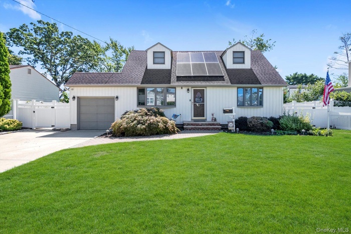 View of front of house with roof with shingles, a gate, an attached garage, and driveway