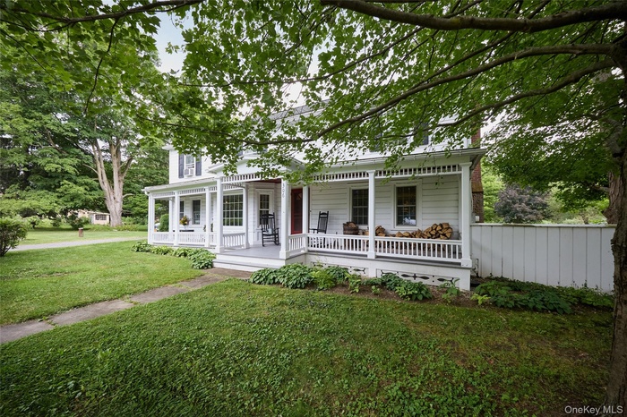 View of front facade with covered porch and a front lawn