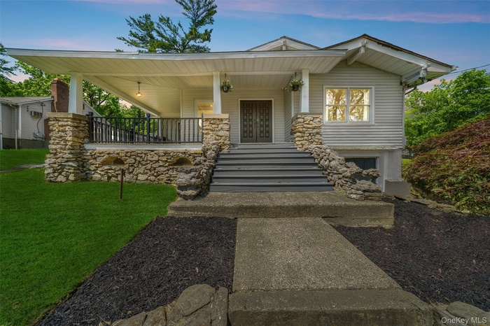 View of front facade featuring a porch, a front yard, french doors, and stairs