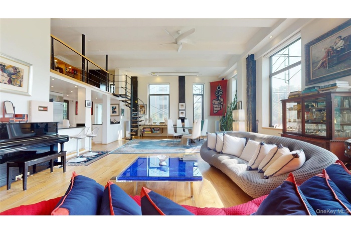 Living room featuring plenty of natural light, wood finished floors, and ceiling fan