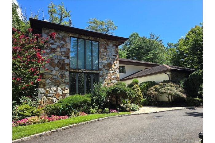 View of front facade with stone siding / circular driveway