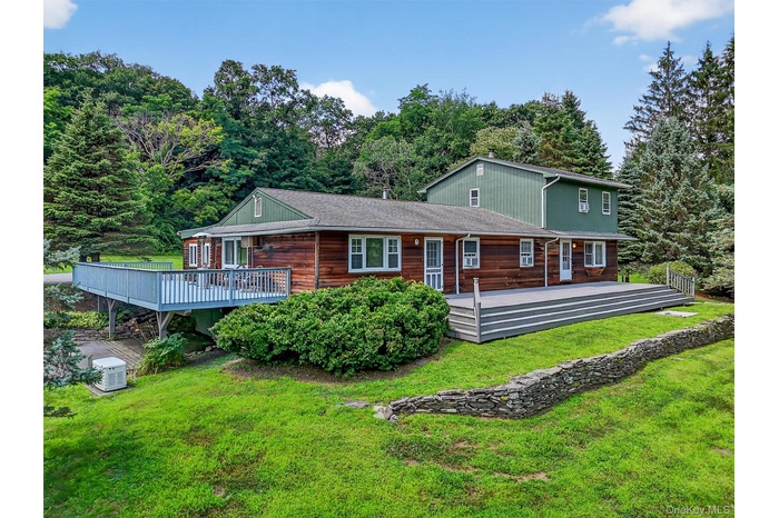 Back of house featuring a deck and a yard