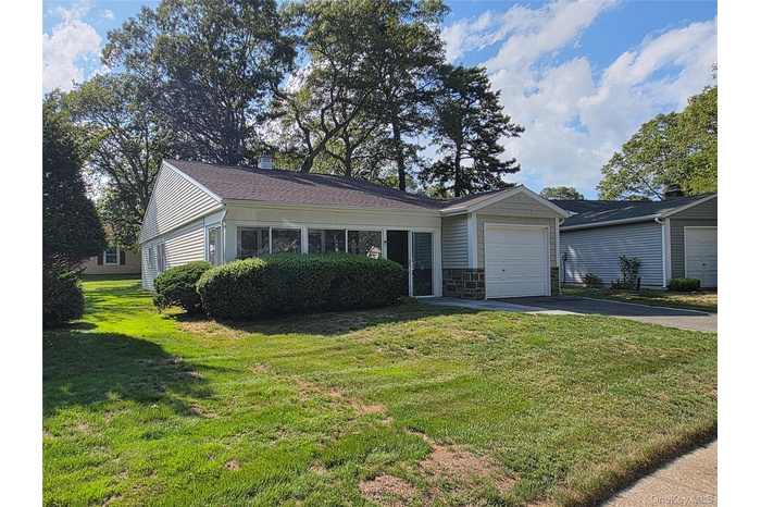 Ranch-style house with a front lawn, asphalt driveway, a garage,  stone and vinyl siding