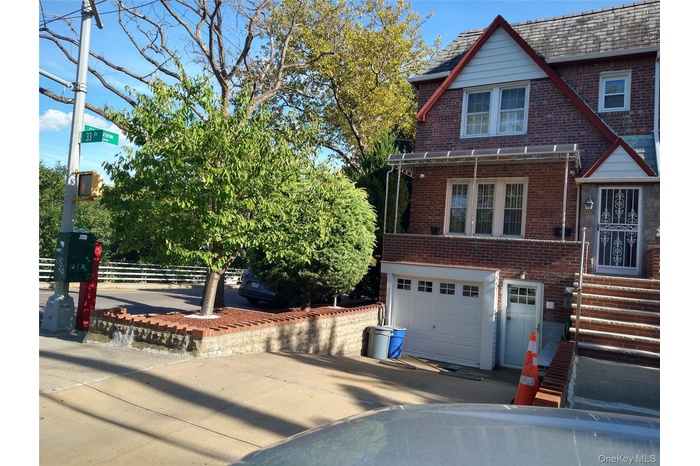 View of front of home with brick siding, concrete driveway, and an attached garage