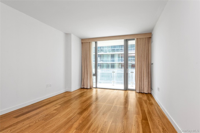 Spare room with light wood finished floors and a wall of windows