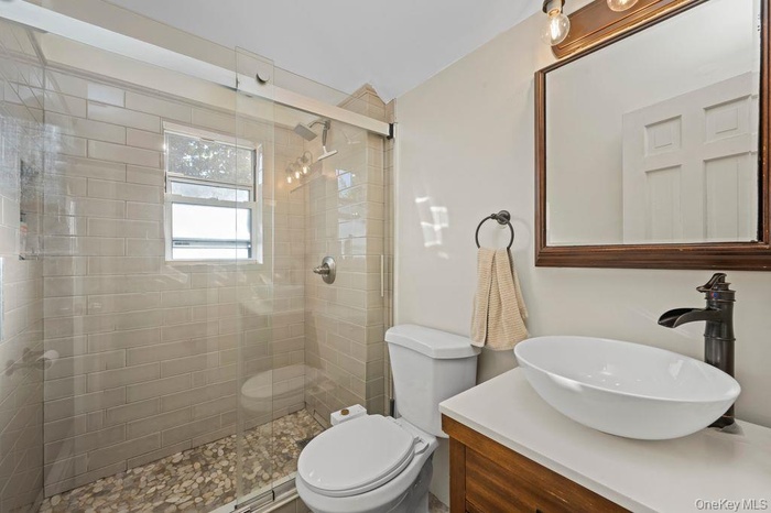 Full bath featuring vanity and a shower stall
