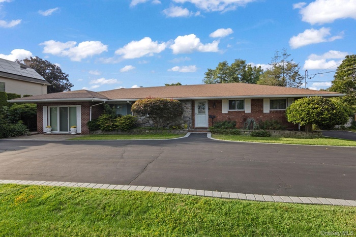 Single story home featuring brick siding and a front lawn