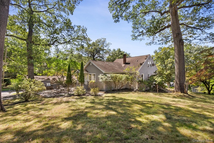 View of green lawn featuring view of wooded area