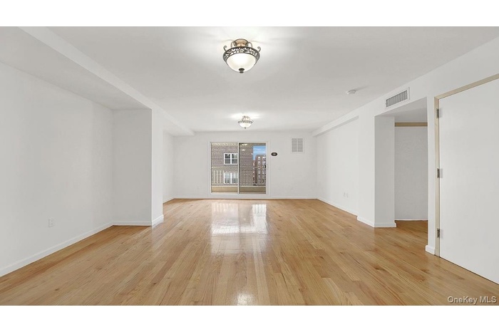 Spare room featuring light wood-style flooring and baseboards