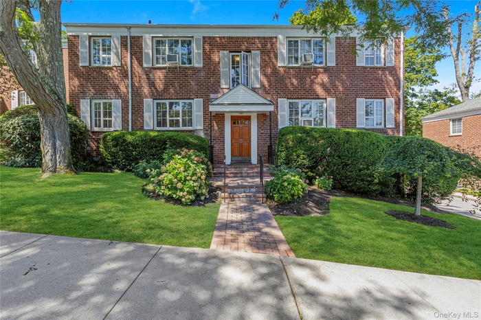 View of front of property featuring brick siding and a front lawn