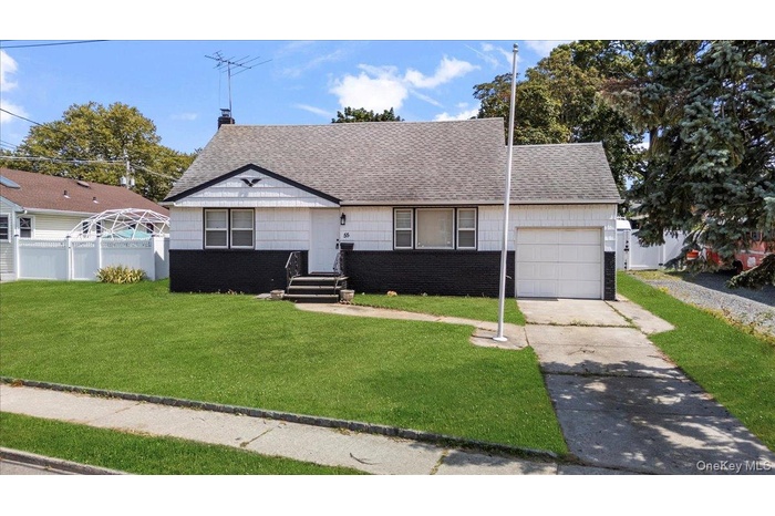 View of front of property featuring a chimney, roof with shingles, brick siding, driveway, and an attached garage
