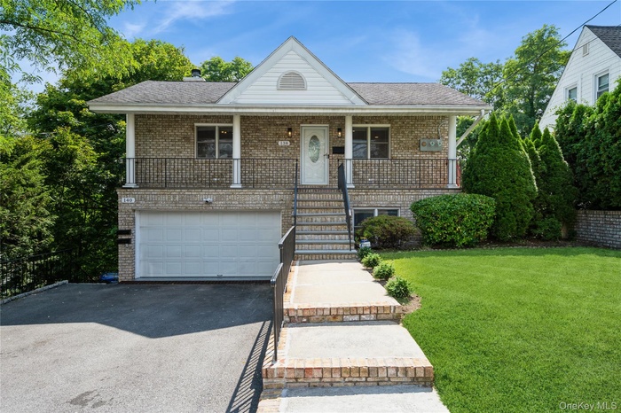 138 Woodside Avenue. Carefully maintained front lawn, driveway parking space.