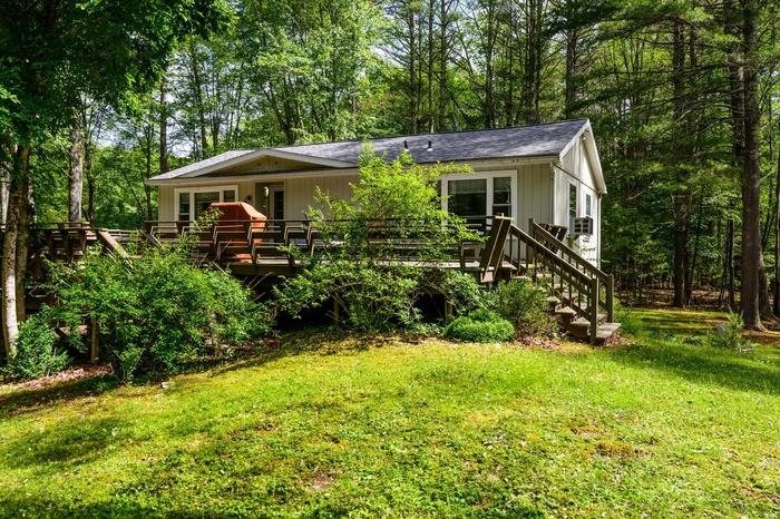 View of front facade featuring a deck and a front lawn