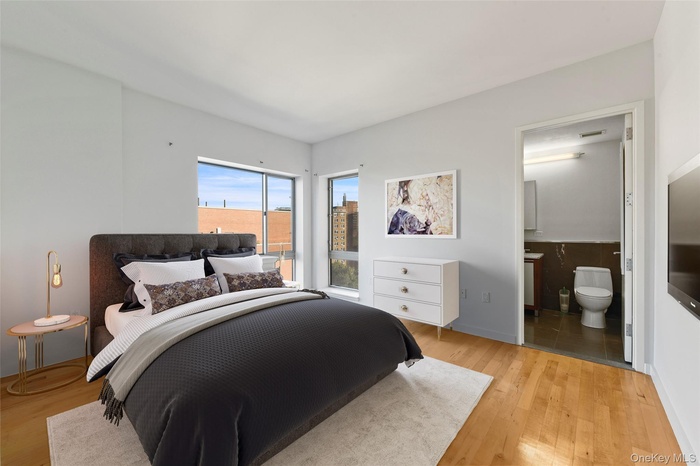 Bedroom with light wood-style floors and ensuite bath