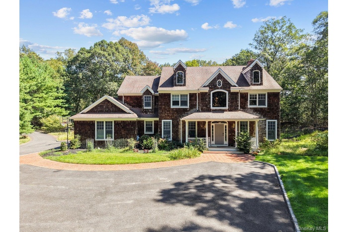 Shingle-style home featuring a porch