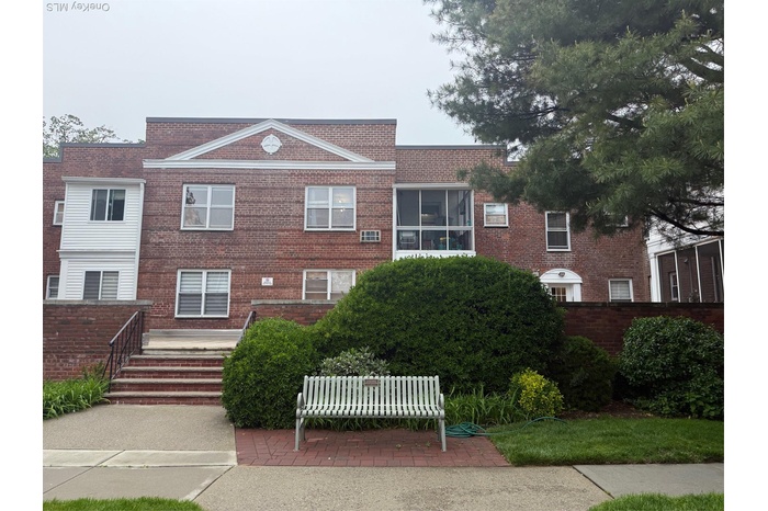 View of front of property with brick siding and fence