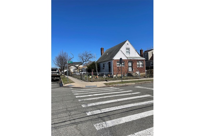 View of asphalt road featuring sidewalks, curbs, and street lighting