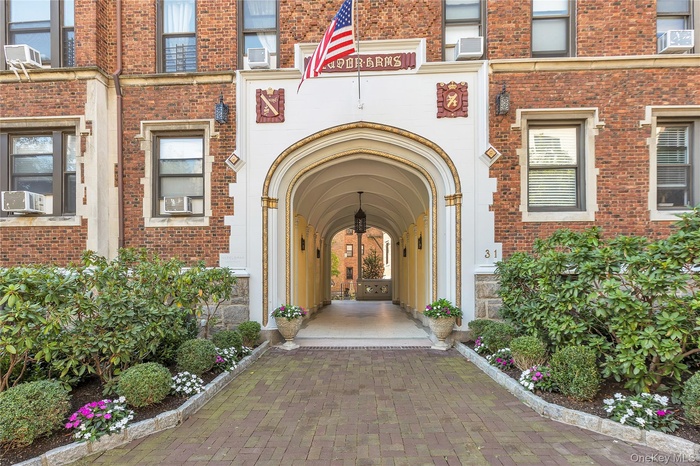View of exterior entry featuring brick siding and cooling unit