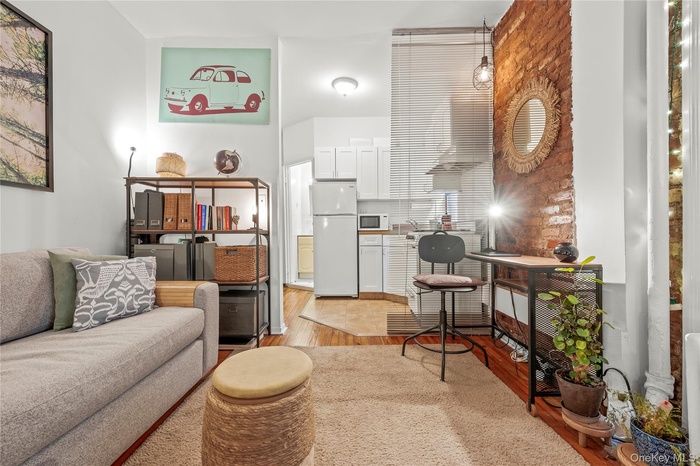 Living area featuring light wood-style floors and brick wall