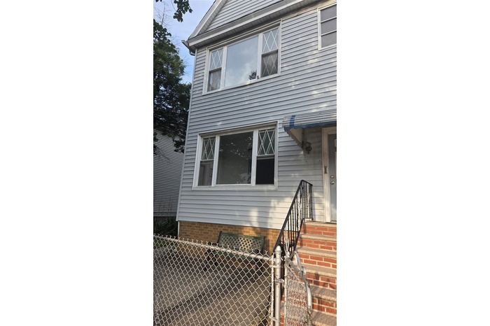 View of side of home featuring a gate